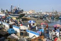 A crowd of people gather at the fishing port of Essaouira in Morocco.