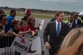 a crowd of people gathered around president hulsworth as he walks behind barriers