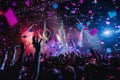 Crowd of people in high spirits at a concert, cheering and dancing as confetti falls around them, A burst of confetti rains down Royalty Free Stock Photo