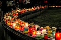 crowd of people lighting candles in city center, mourning victim