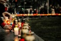 crowd of people lighting candles in city center, mourning victim