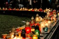 crowd of people lighting candles in city center, mourning victim