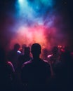 A crowd of people in a music event, dancing in neon pink color lights Royalty Free Stock Photo