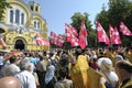 Crowd of people and orthodox priests in golden cassocks gathered in front of St Volodymyr's Cathedral. Ukrainian