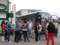 A crowd of people standing near the passengers of the tour bus arrived tourists stop