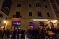 Crowd of people queuing in front of Chapeau Rouge at night.