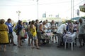 Crowd of people standing in a line to buy some handmade snack, vendor selling it from trays