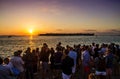 Crowd of people watching a beautiful colorful sunset from Key West with Sunset Key on the horizon. Key West, FL USA - 25/04/2018