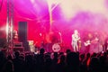 A crowd of people watching a musical group performing on stage Royalty Free Stock Photo