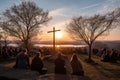 Crowd of people watching the sunset over the lake and the cross. Easter morning