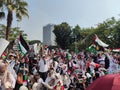 Crowd of people waving Palestinian flag in a demonstration