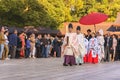 Crowd photographing Shinto priests and maidens guiding a couple during a Japanese wedding.