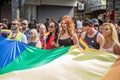 Crowd of protestors holding a giant rainbow gay flag during the Belgrade Gay Pride, happy and smiling