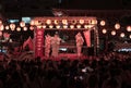 Crowd raising their arms towards Japanese idols at the Kanda Myojin Bon Odori dance at night.