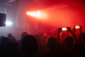 Crowd on the rock show. Silhouettes of people on the concert. Fans dancing and raising hands in front of the stage