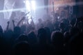 Crowd on the rock show. Silhouettes of people on the concert. Fans dancing and raising hands in front of the stage