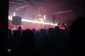 Crowd on the rock show. Silhouettes of people on the concert. Fans dancing and raising hands in front of the stage