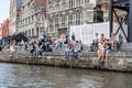 A crowd of students sitting on riverside of Embankment Graslei i