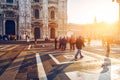 Crowd of tourist people walking in center of old town near Duomo in Milan, Italy at sunset time.