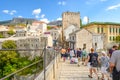 A crowd of tourists cross over the restored Mostar Bridge in the city of Mostar, Bosnia, as they make their way into old town Royalty Free Stock Photo