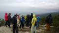 The crowd of tourists on the hill sees the panoramic view from the top.