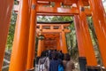 Crowd of visitors under the torii gates of the Fushimi Inari shrine in Kyoto, Japan