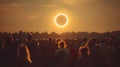 Crowd watching solar eclipse at sunset over forest horizon Royalty Free Stock Photo