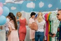 Crowd of women inside cute fashion shop with colorful female clothing