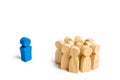 The crowd of wooden figures of people stand distantly and look at the red man. The rejected person tries to establish contact with Royalty Free Stock Photo