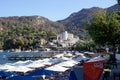 Crowded beach in touristic resort village in Turkey. Small picturesque village by the sea. Seaside embankment with