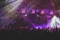 A crowded concert hall with scene stage lights, rock show performance, with people silhouette, colourful confetti explosion fired