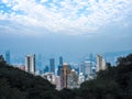 Crowded Hong Kong skyline scene with tightly packed skyscrapers and apartment buildings with green tropical mountain background Royalty Free Stock Photo