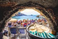 Crowded little beach in italy old seaview boathouse - stone arch - San Fruttuoso abbey - italian riviera - italy