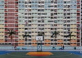 Crowded narrow apartments in the building of Choi Hung public housing estate in Kowloon, Hong Kong, with a basketball stand in the Royalty Free Stock Photo