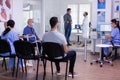 Crowded new normal hospital waiting room with patients sitting on chairs