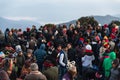 Crowded people are waiting for the first light in the dawn of new year`s day with mountain and fog in background at Tiger Hill.