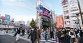 Crowded people walk cross road, car traffic transportation in Shinjuku shopping business district Royalty Free Stock Photo