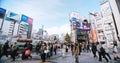 Crowded people walk cross road, car traffic transportation in Shinjuku shopping business district Royalty Free Stock Photo