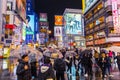 Crowded people walking in colorful night raining street in Dotonbori high street