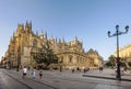 Crowded road full of tourists and the cathedral of Seville at dusk, Spain