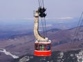 Crowded ski gondola and snow mountains background