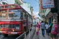 Crowded street with people and big red bus