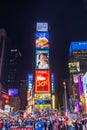 Crowded Times Square at night with vibrant digital billboards and illuminated advertisements.