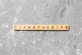 CROWDFUNDING word written on wood block. CROWDFUNDING text on cement table for your desing, concept