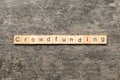 CROWDFUNDING word written on wood block. CROWDFUNDING text on cement table for your desing, concept