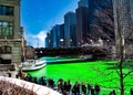 Crowds gather along the Chicago River riverwalk near Michigan Avenue. The water is dyed green for St. Patrick`s day.