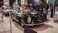 Crowds looking at new car models at Auto show. Mercedes vintage car on display. National Canadian Auto Show with many car brands.