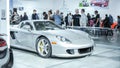 Crowds looking at new car models at Auto show. Porsche Spyder car on display. National Canadian Auto Show with many car brands.