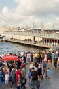 Crowds of pedestrians at Eminonu Plaza during Victory Day holiday with Galata Bridge in the background, Istanbul, Turkey