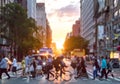 Crowds of people cross a busy intersection in New York City